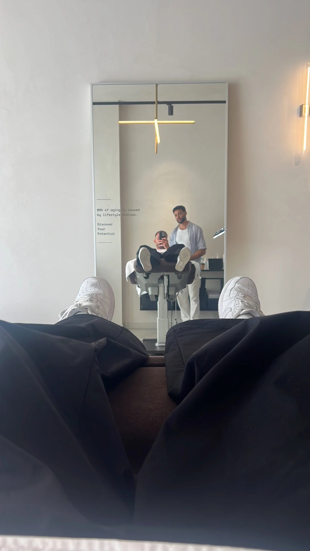 Client’s perspective during a treatment at Salon d’Homme, showcasing the modern interior, mirror reflections, and relaxed ambiance