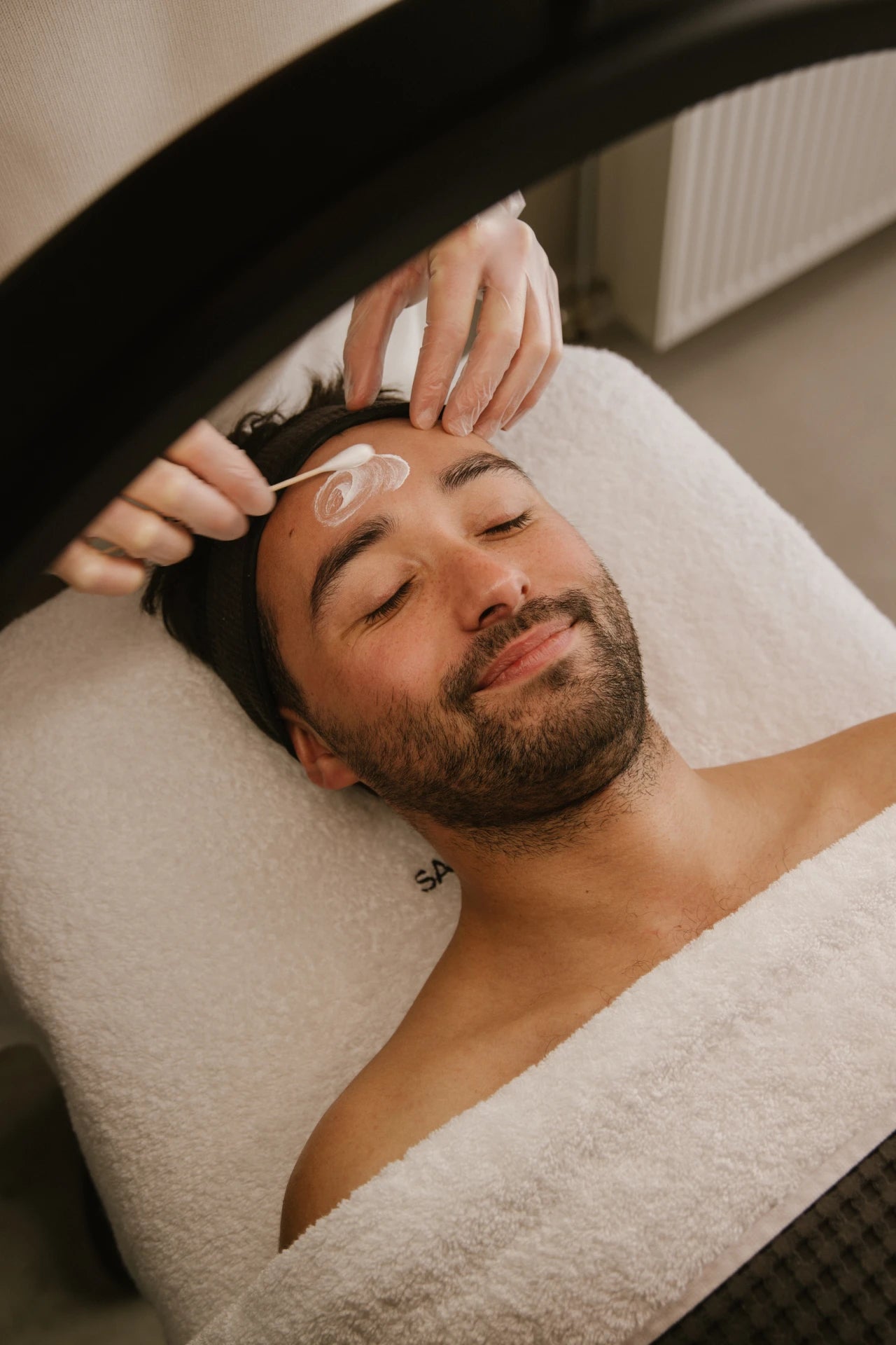 A soothing enzyme peel being expertly applied to a client’s forehead at Salon d’Homme, for radiant and even skin.